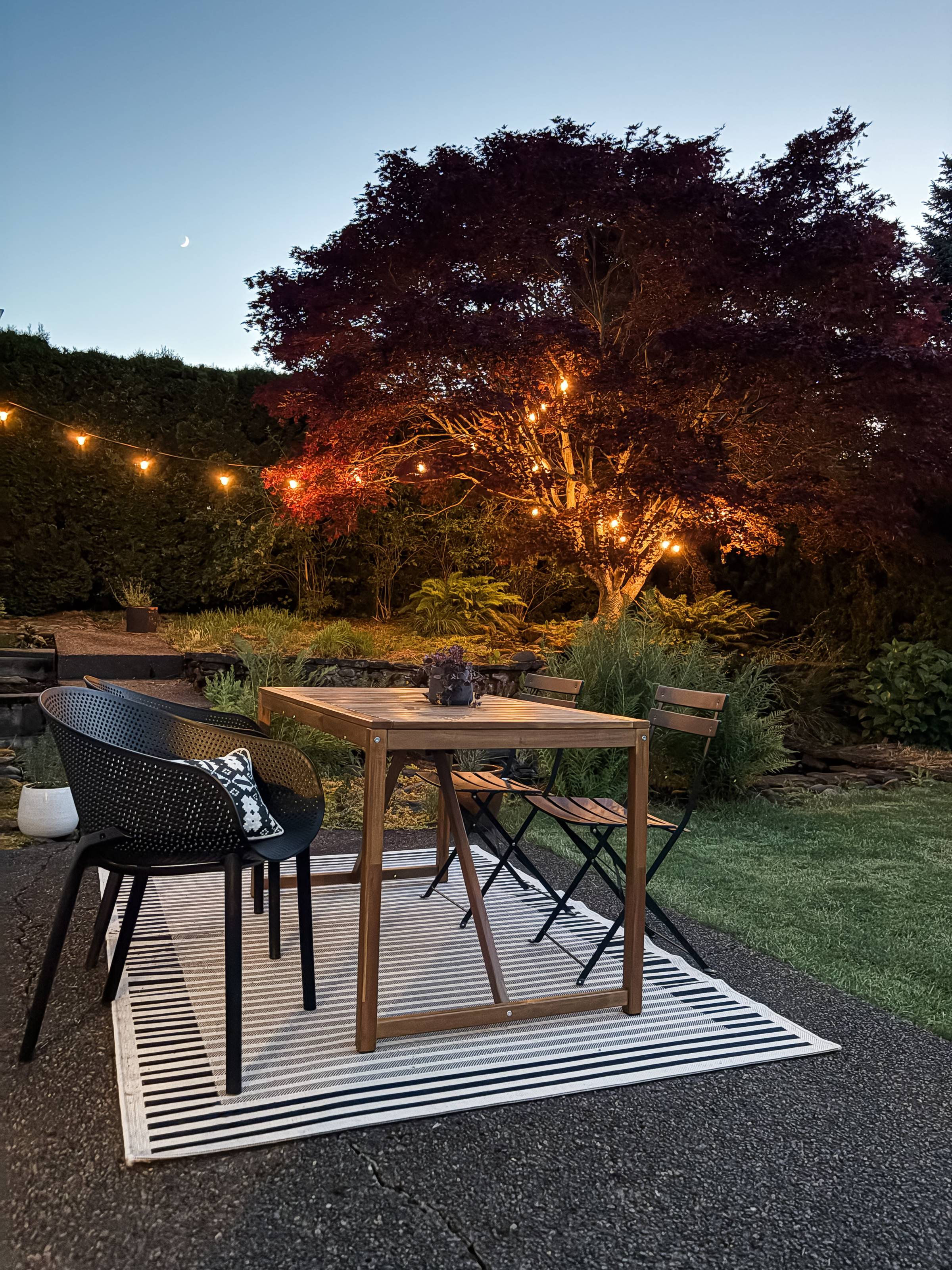 backyard patio with table, chairs, and lights