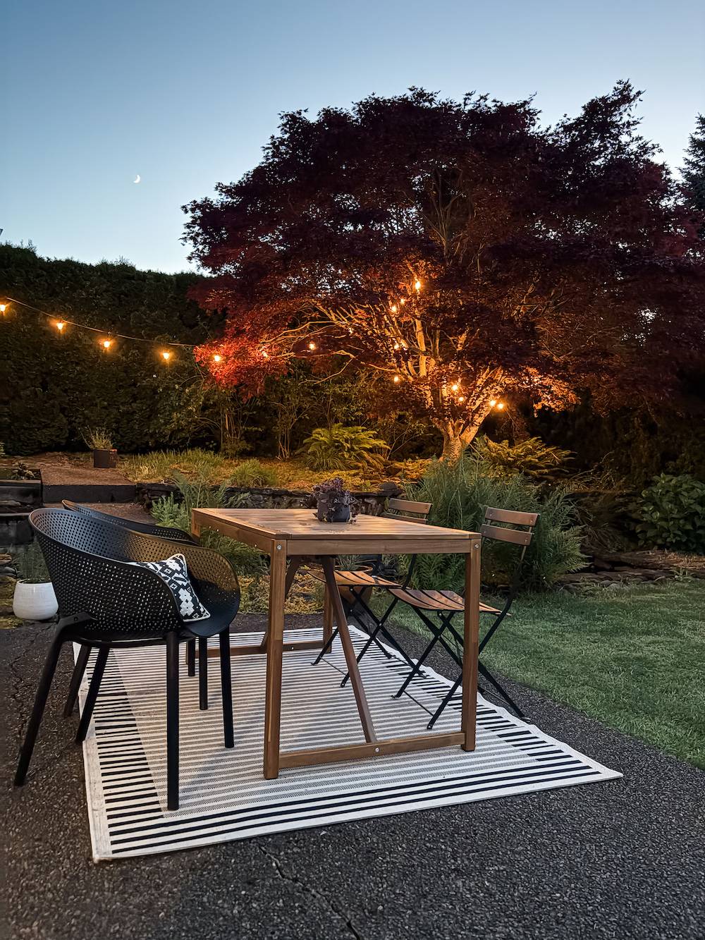 backyard patio with table, chairs, and lights