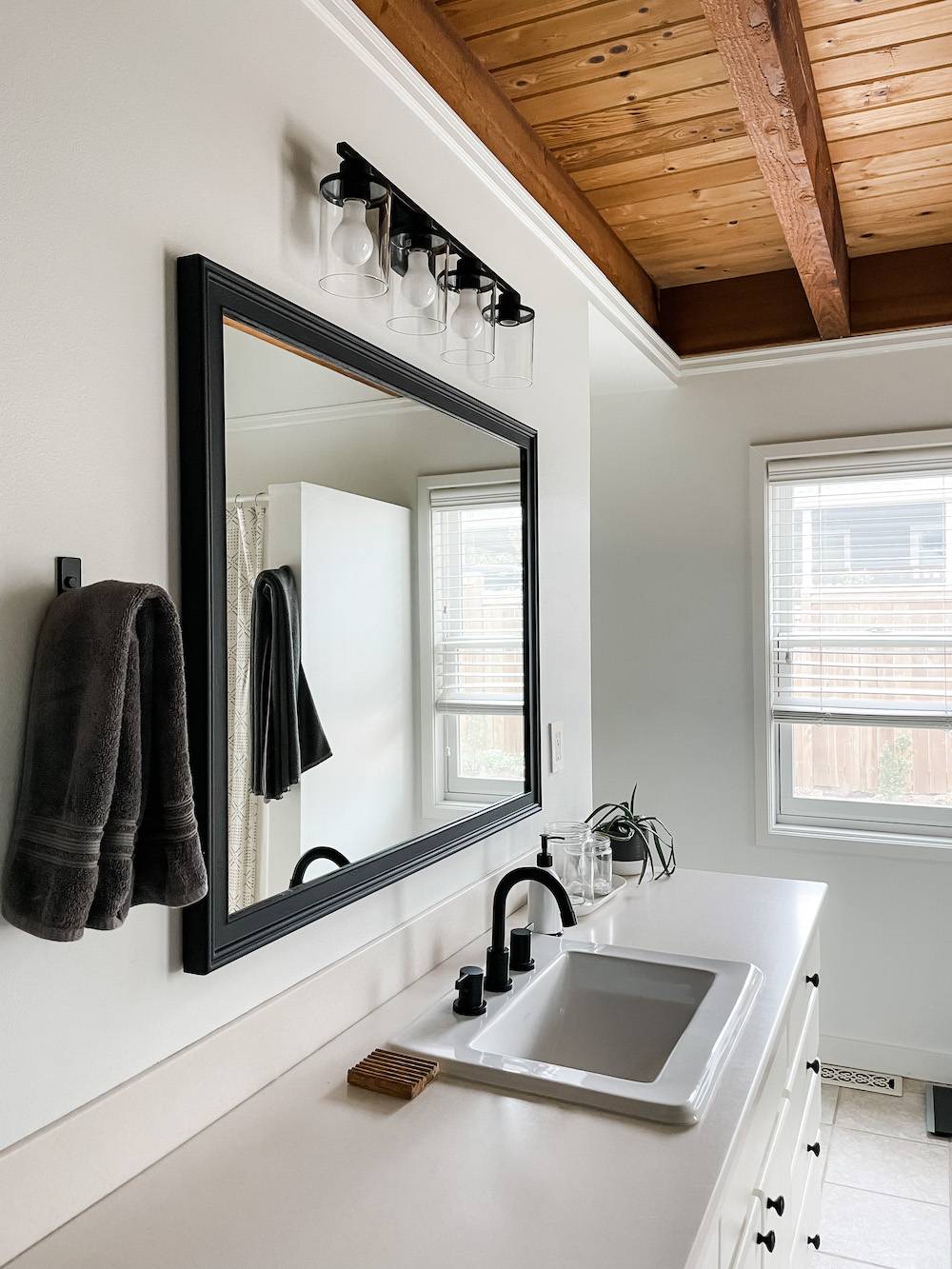 white bathroom with black mirror and hardware