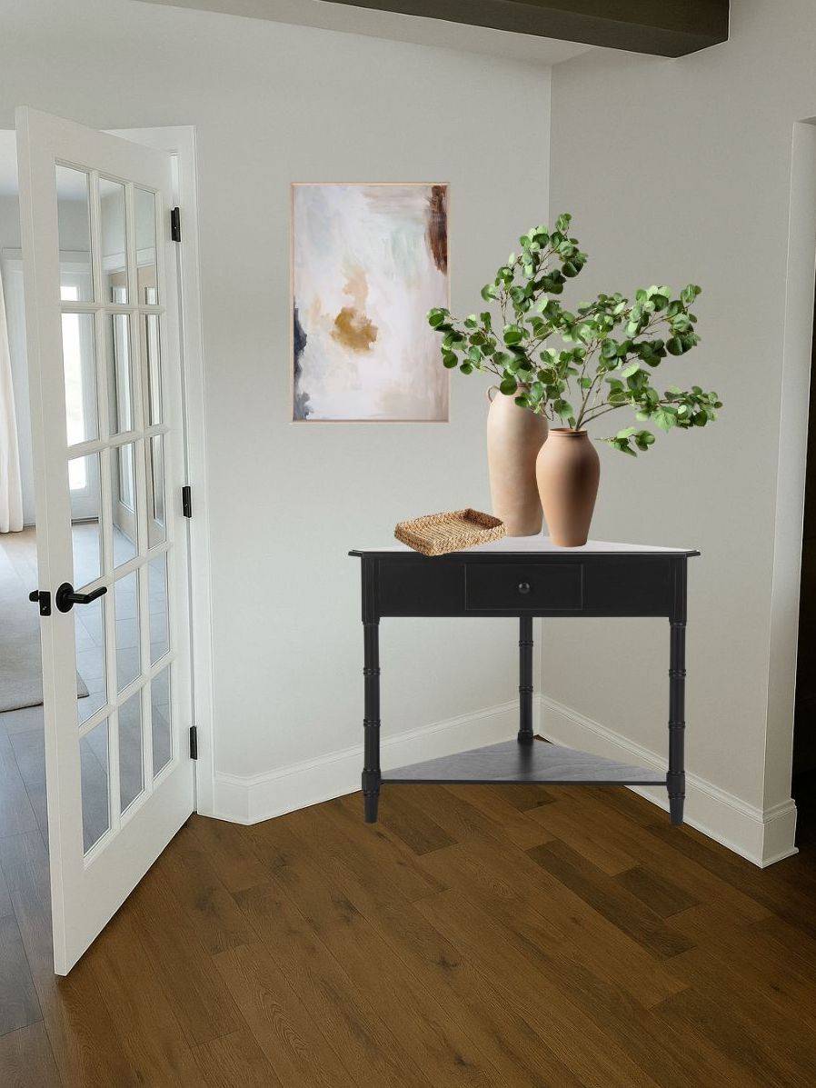 entryway with black table, lamps, and artwork