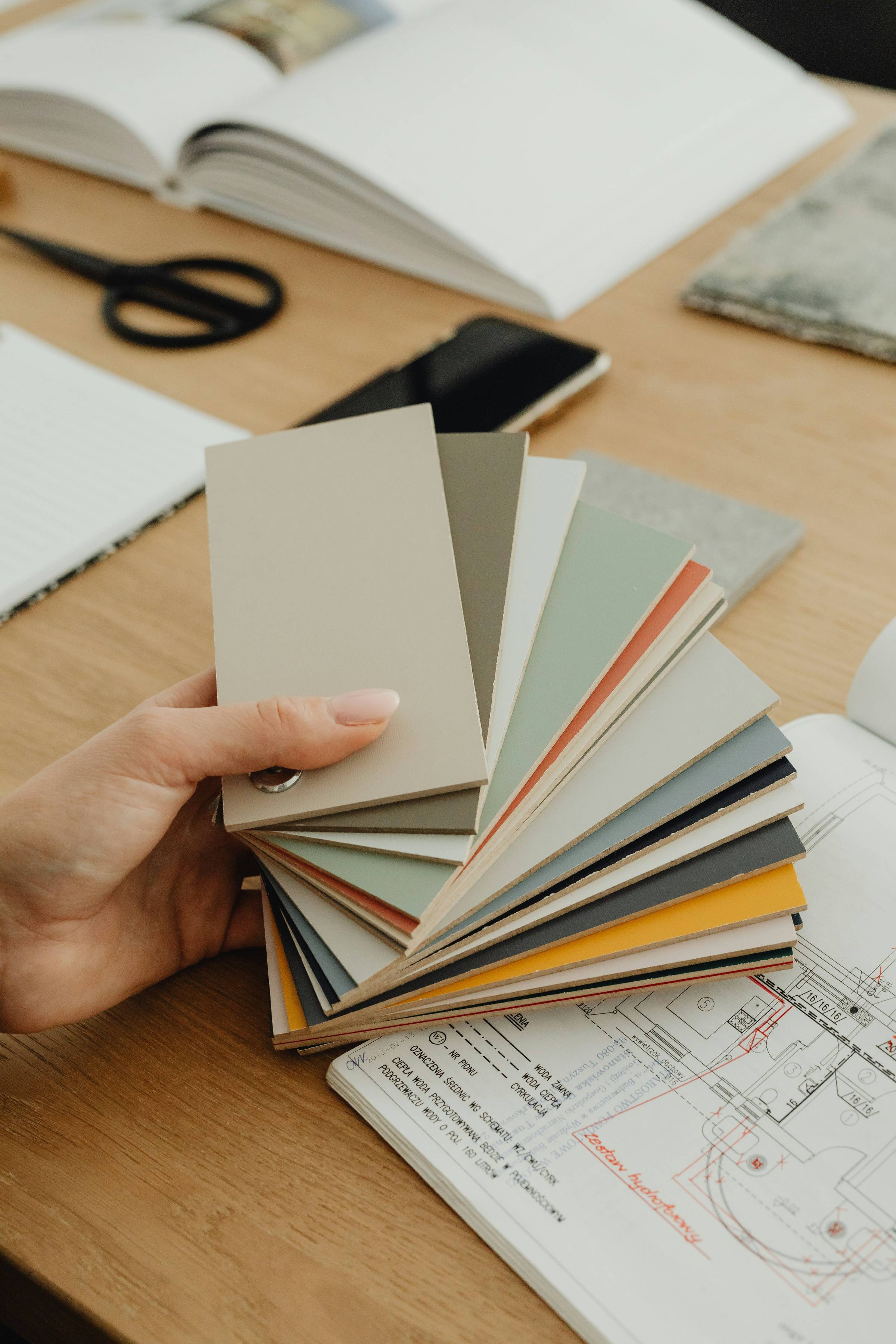woman's hand holding paint chips with neutral colors