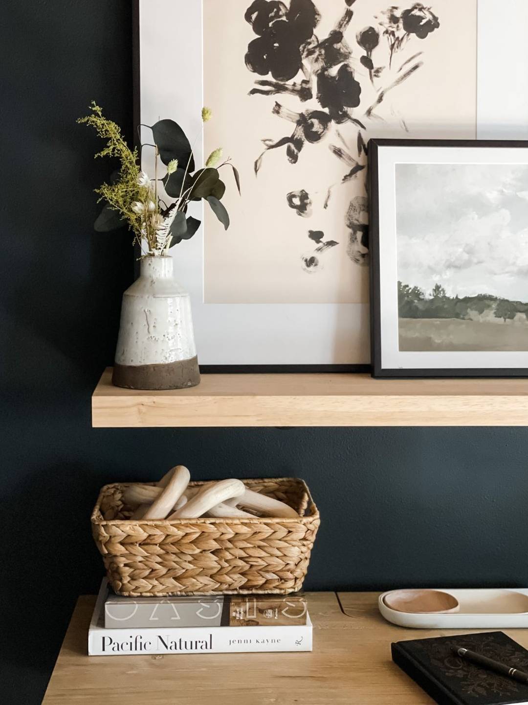 desk area with shelf, artwork, and basket