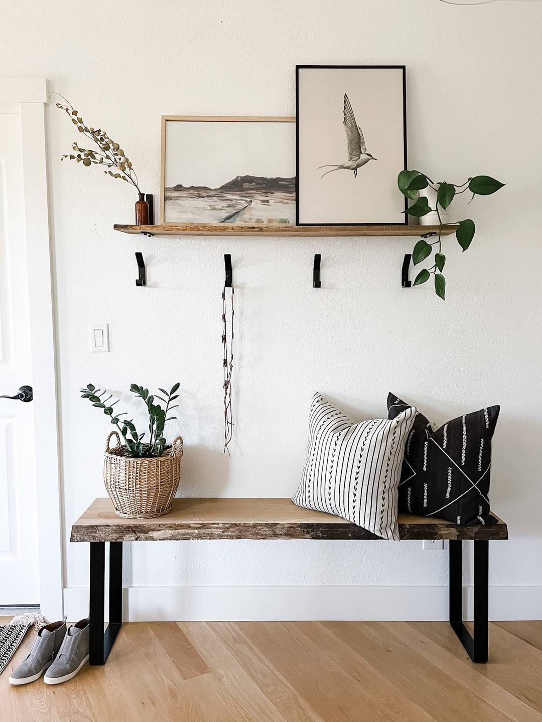 entryway with bench, hooks, and artwork