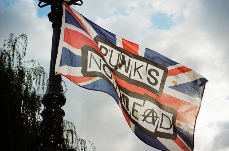 A flag flying in the wind on top of a lamp post