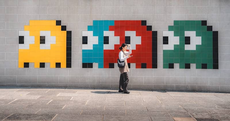 Person stands before pixelated ghost art on wall