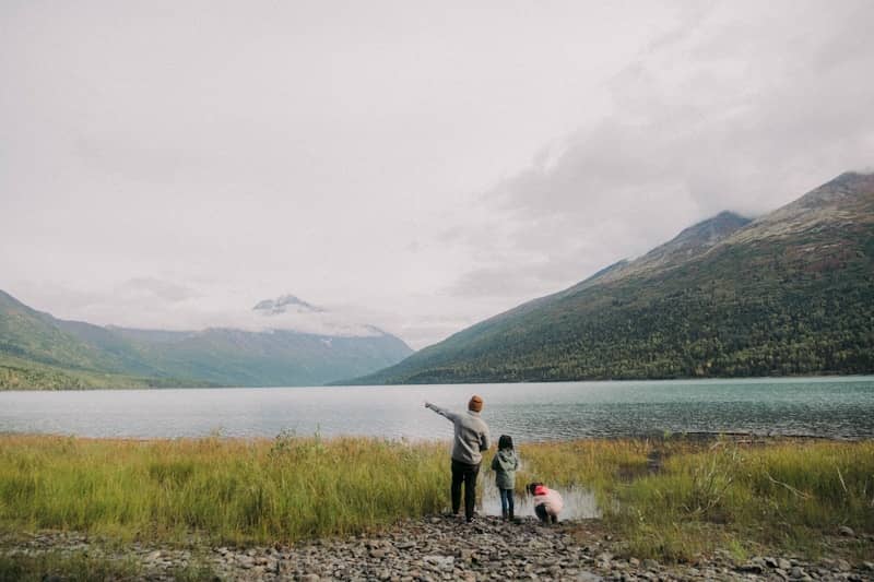 a couple of people standing next to a body of water