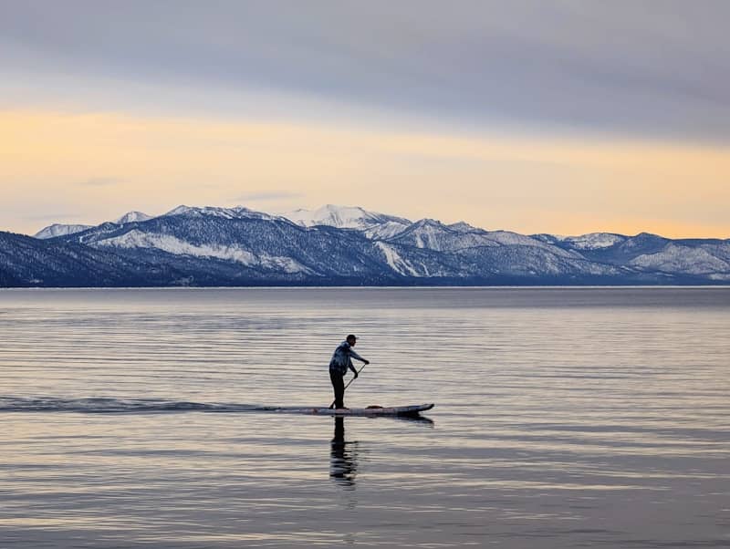 A man riding a paddle board on top of a lake
