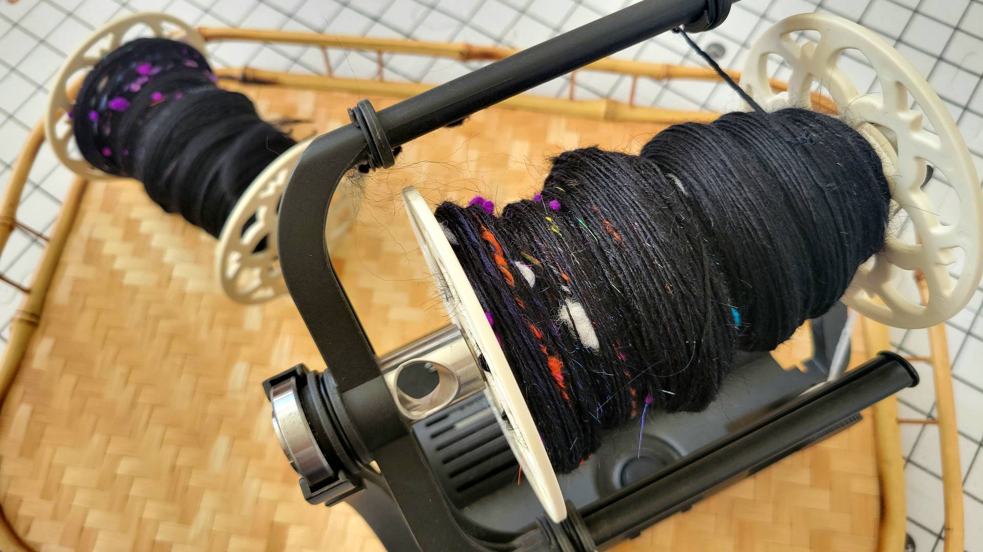 Second singles in process of being spun on e-spinner with finished singles on bobbin in background.