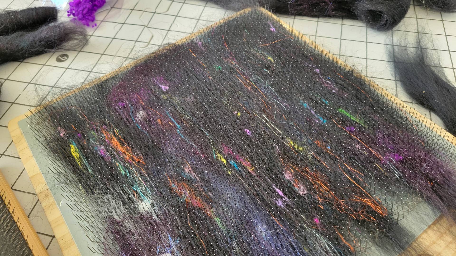 Black fiber with pops of color on blending board.