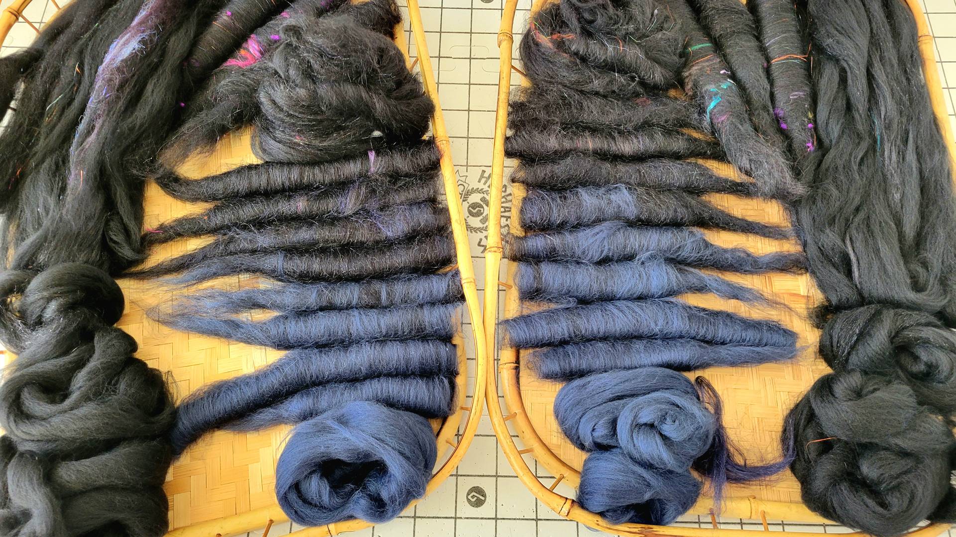 Blue and black rolags and fiber prepared for spinning to create a fade between the colors.