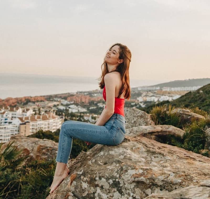 woman sitting on rock during daytime