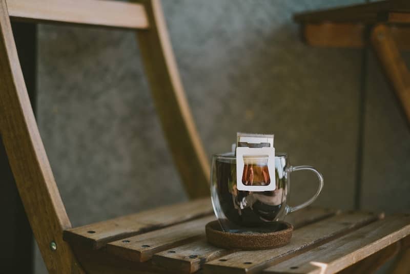 Coffee is brewing in a glass cup.