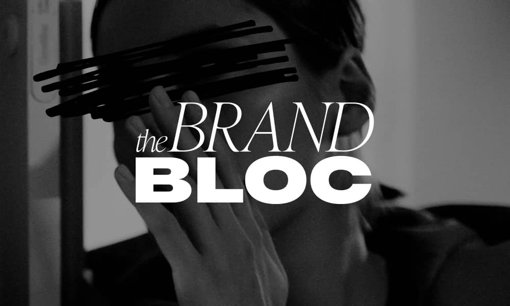 Woman whispering secret with The Brand Bloc logo