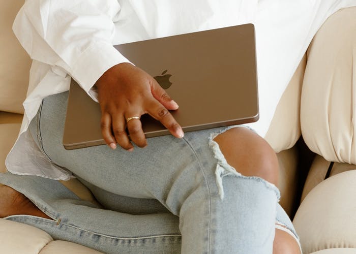 Shavaun holding a laptop on a sofa