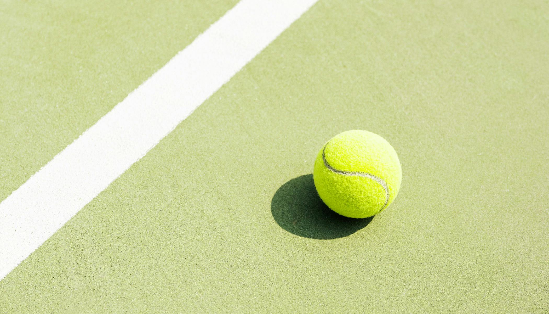 Tennis ball on hardcourt surface; Photo by Alan Macías