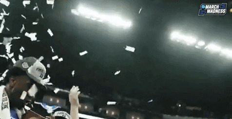 Champion college basketball player throwing confetti in air.