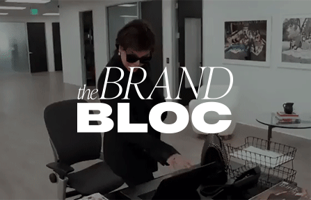 Shutting laptop closed with The Brand Bloc logo.