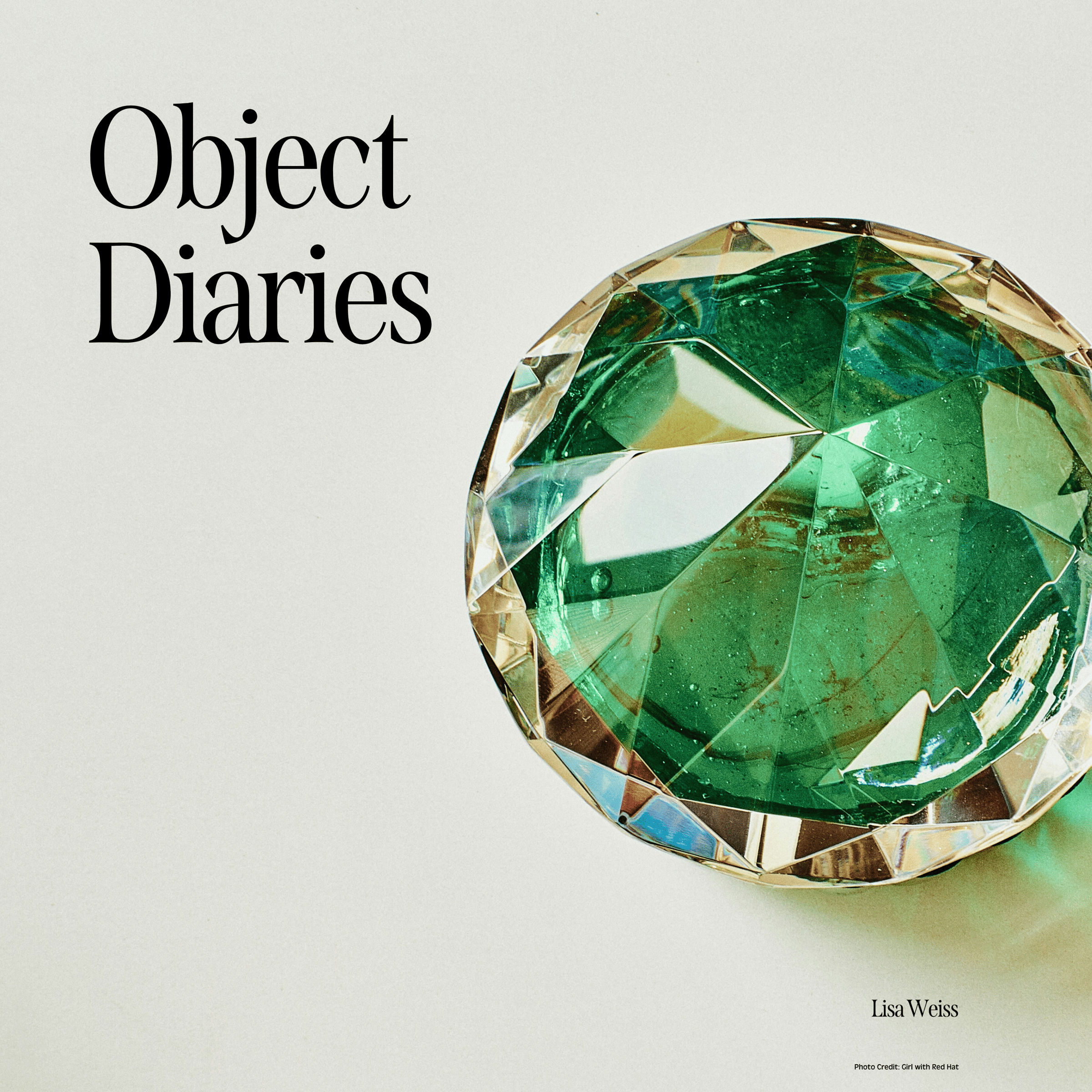 "Object Diaries" against an antique white backkground, a  green glass paperweight to the right