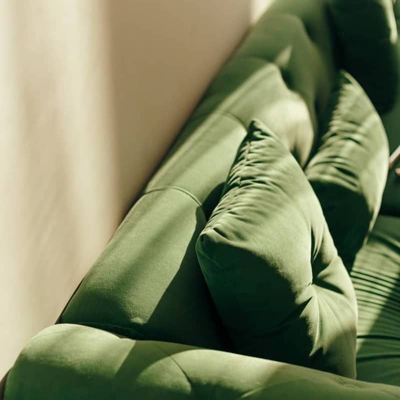 A plush green sofa with soft cushions.