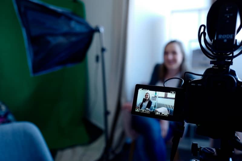 a woman sitting in front of a green screen