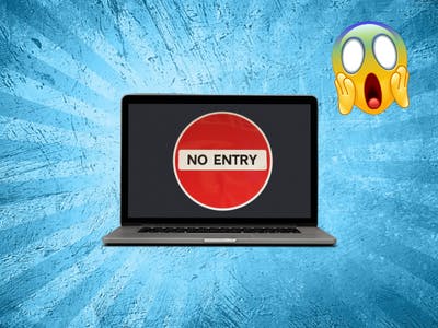 A laptop with a "No Entry" sign on the screen and a panic emoji