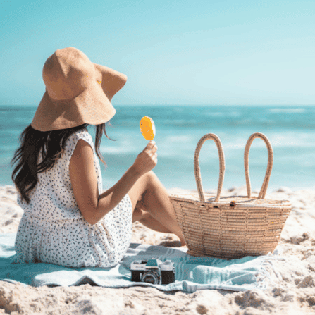 Girl sitting on the beach with a popsicle