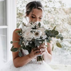 Bride smelling flowers on wedding day