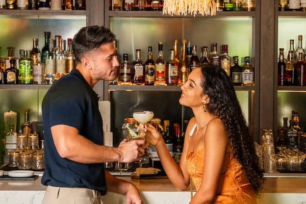 Couple having drinks by the bar, Thesis Hotel