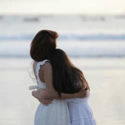 mom & daughter hugging on the beach 