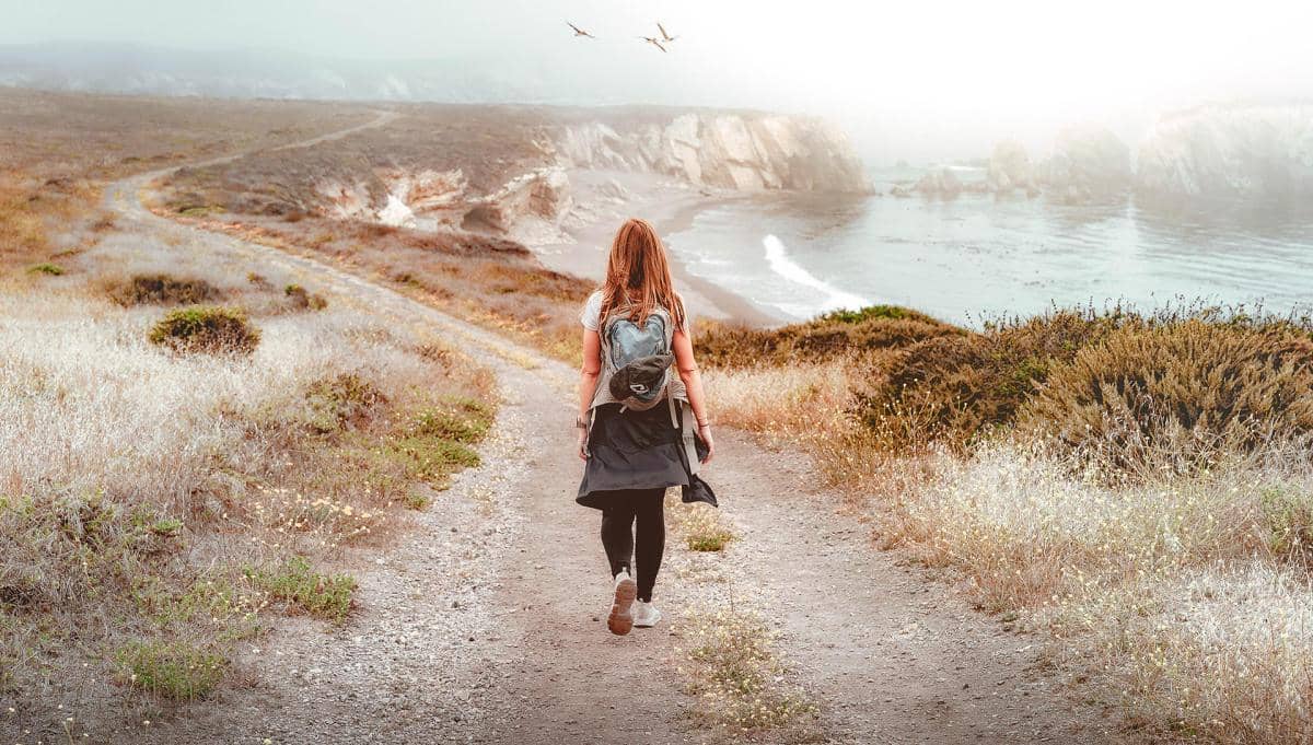 woman walking on a path with ocean view