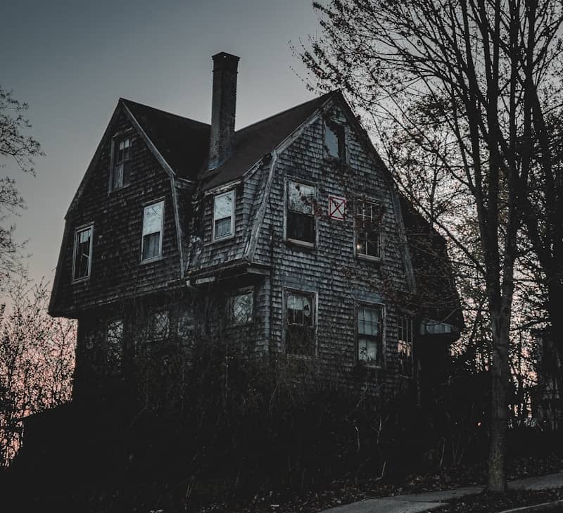 A spooky, abandoned house underneath a gloomy sky.