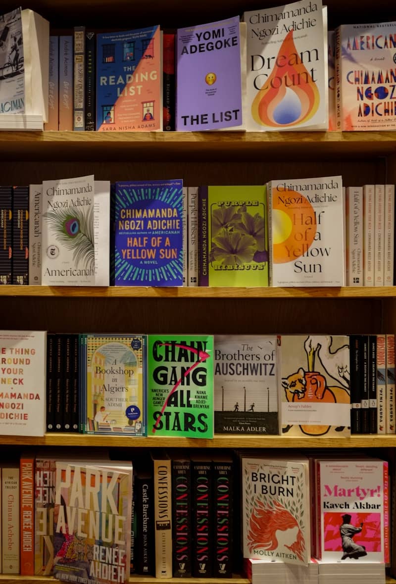 Books displayed on wooden shelves in a bookstore.