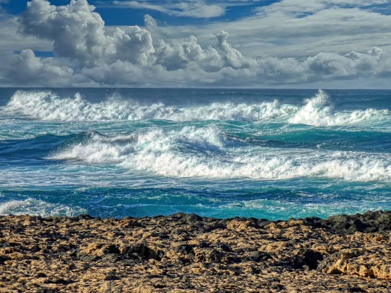 Rough ocean waves crashing under a cloudy sky.