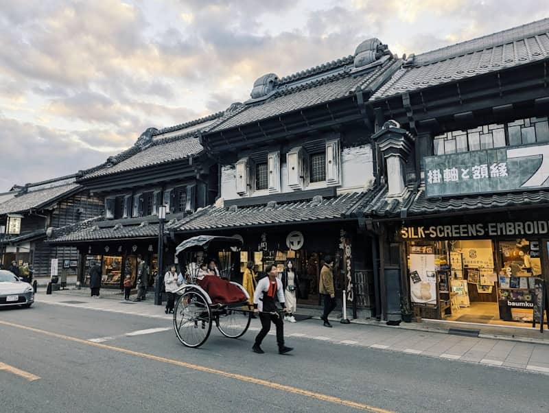 Rickshaw pulled along a street with traditional buildings.