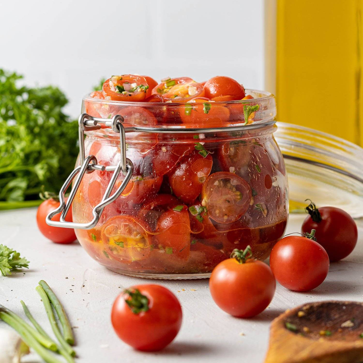 Marinated grape tomatoes in a small glass jar.