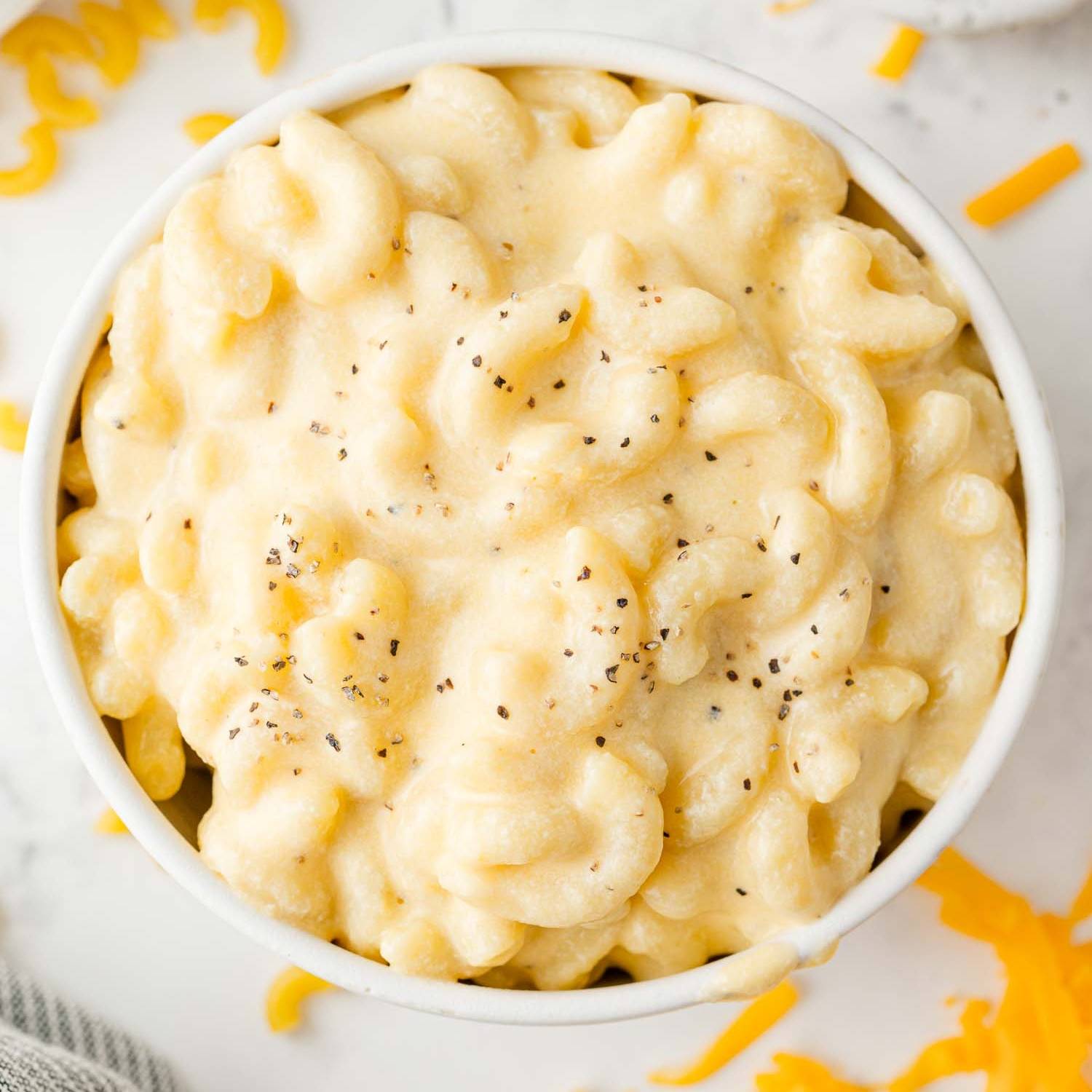 Creamy macaroni and cheese topped with pepper in a white bowl.
