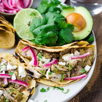 Pork tacos with colorful toppings.
