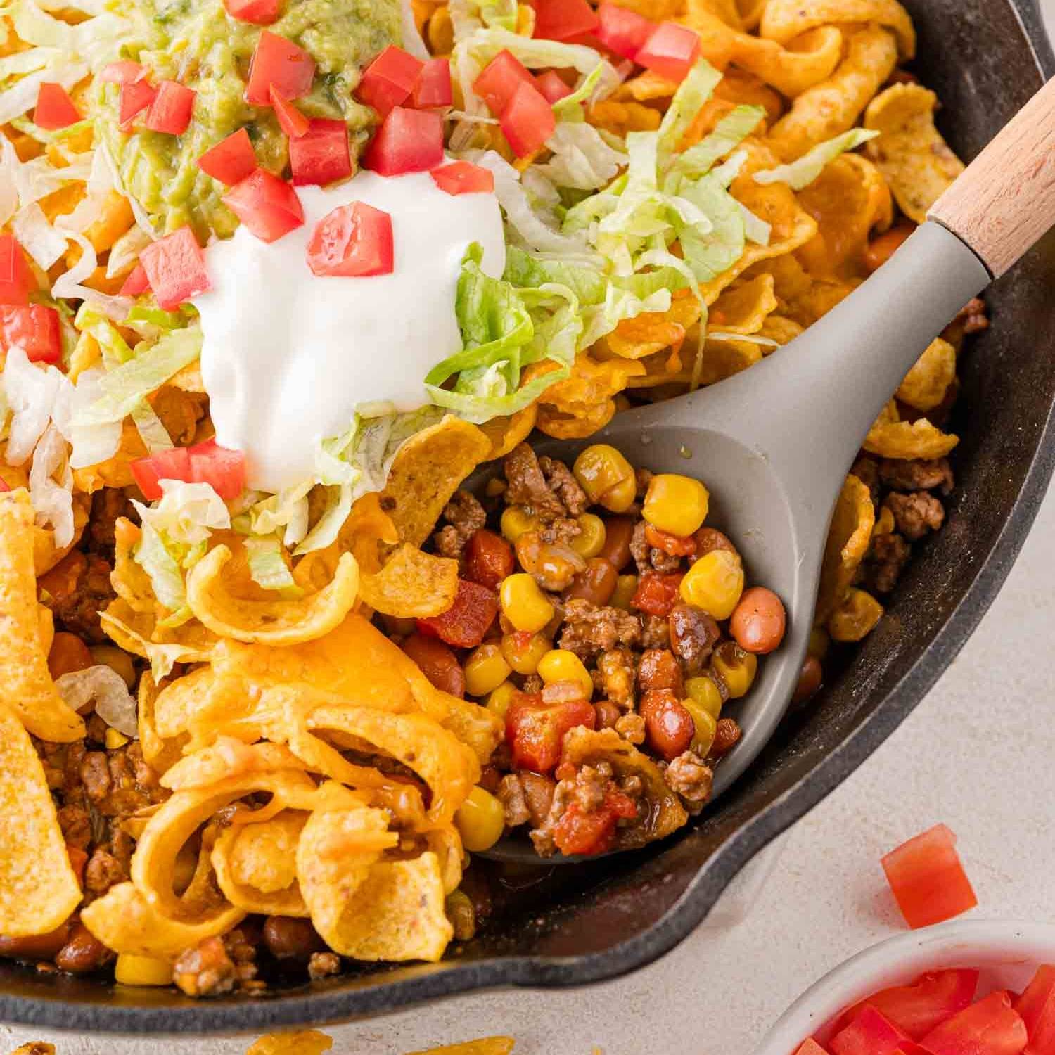 Walking taco casserole in black skillet.
