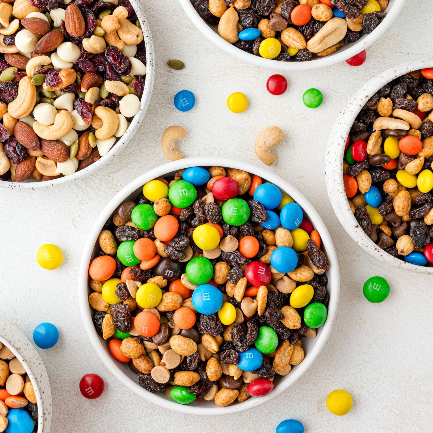 Multiple bowls of different kinds of trail mix.
