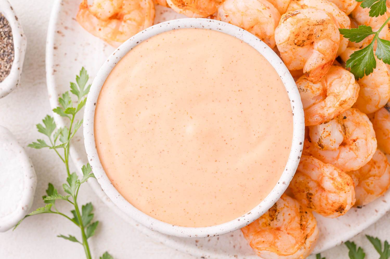 Yum yum sauce in a small bowl next to grilled shrimp.
