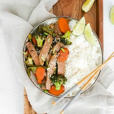 Sesame beef and vegetables in a bowl with rice.