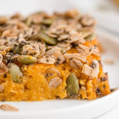 Sweet potato casserole topped with oats, pepitas, and chia seeds.