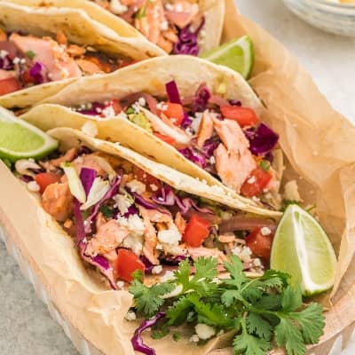 Salmon tacos wiht slaw and lime wedges.