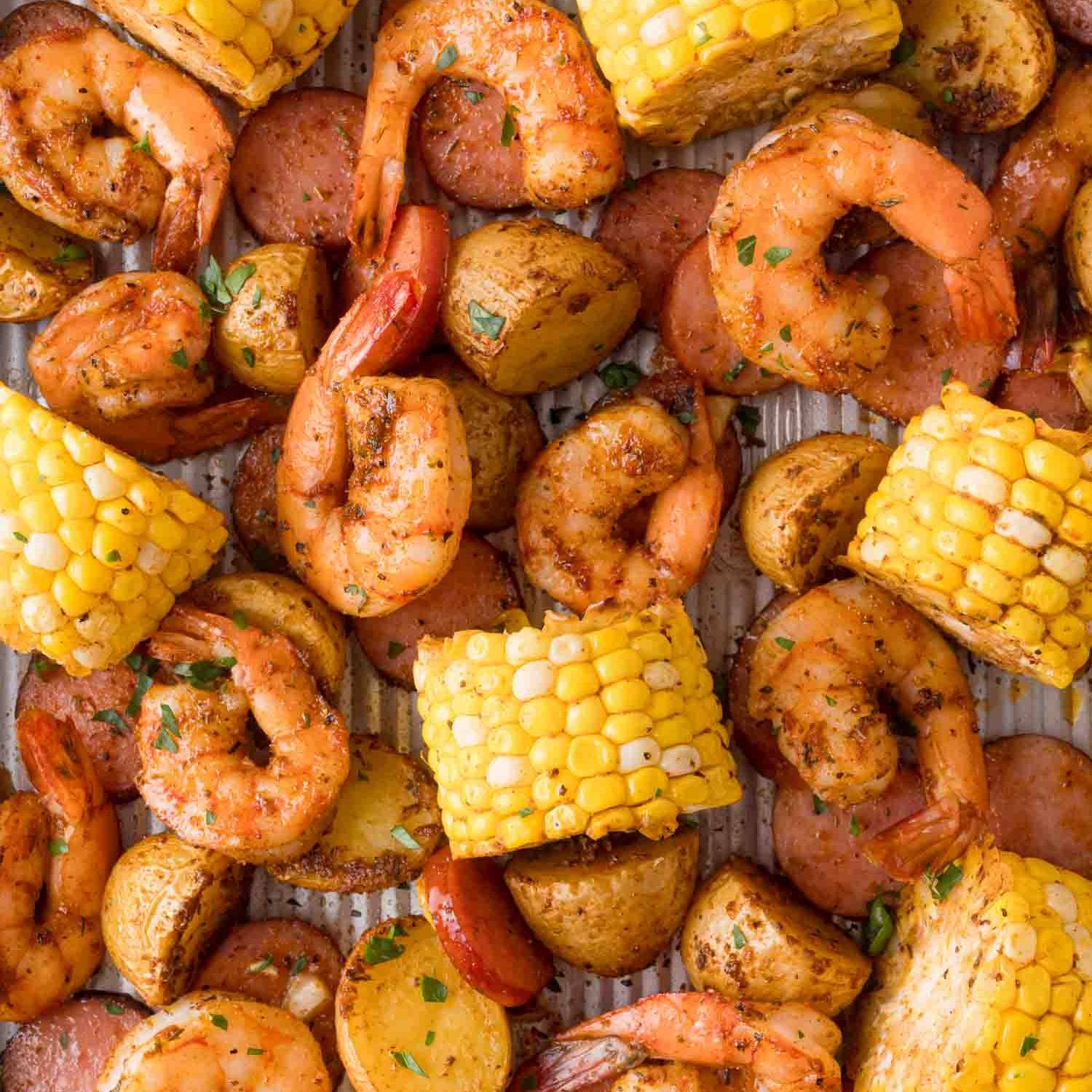 Shrimp, corn on the cob, potatoes, and sausage on a sheet pan.