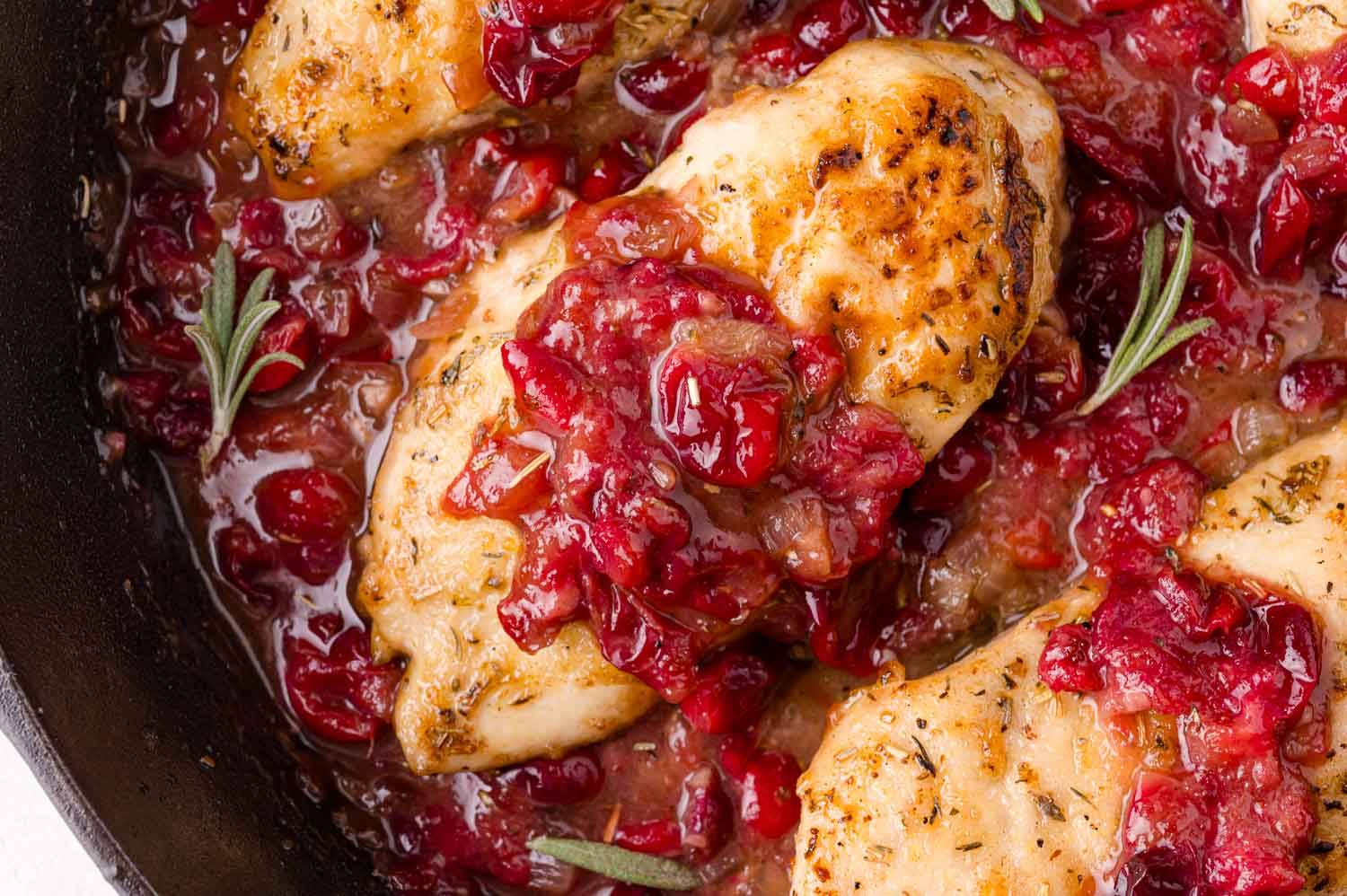 Cranberry chicken in a black pan.