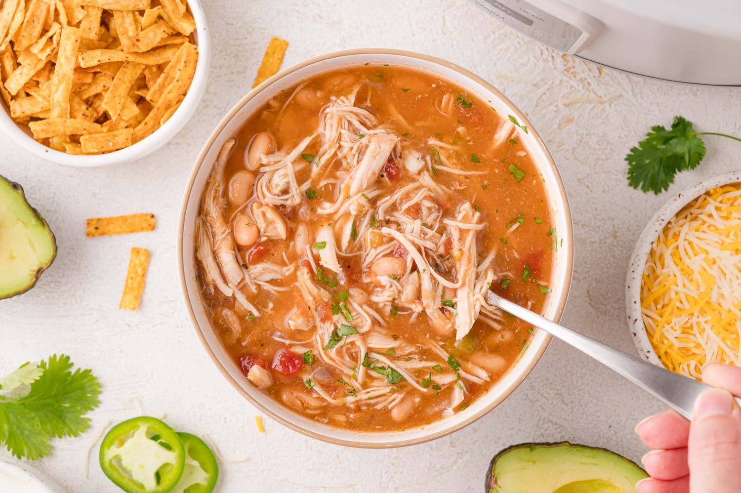 Crockpot white chicken chili in a bowl with a spoon.