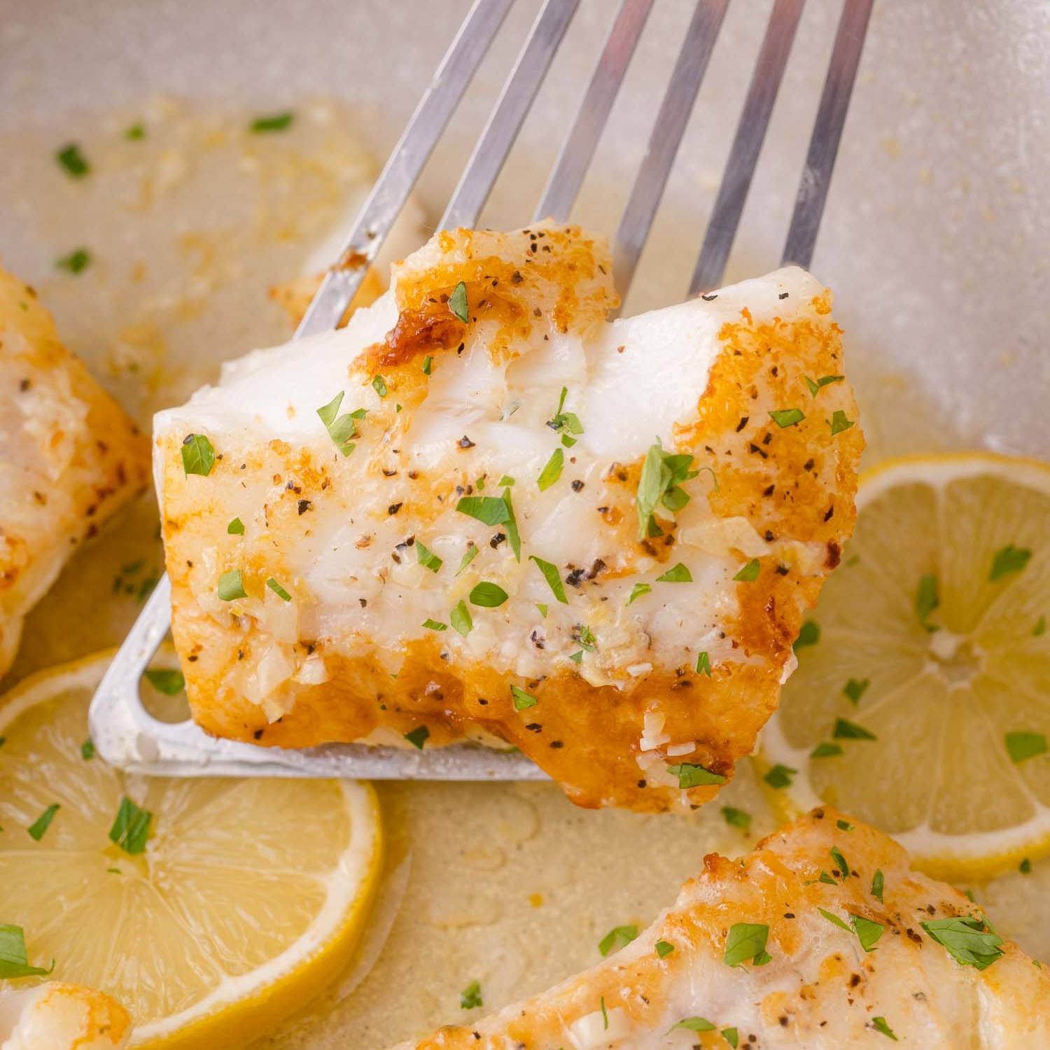 Lemon butter cod, one fillet being picked up with a spatula.
