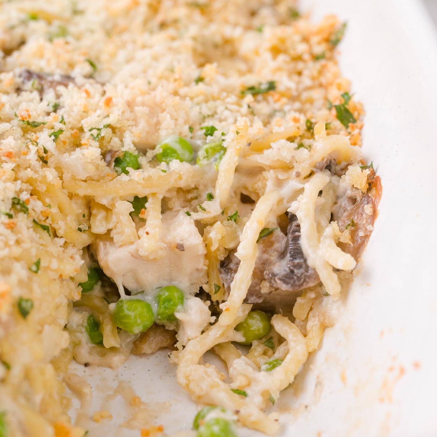 Chicken tetrazzini in a baking dish with a scoop removed.