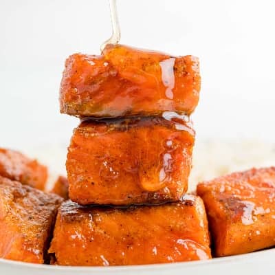 Salmon bites stacked up, with a drizzle of honey.