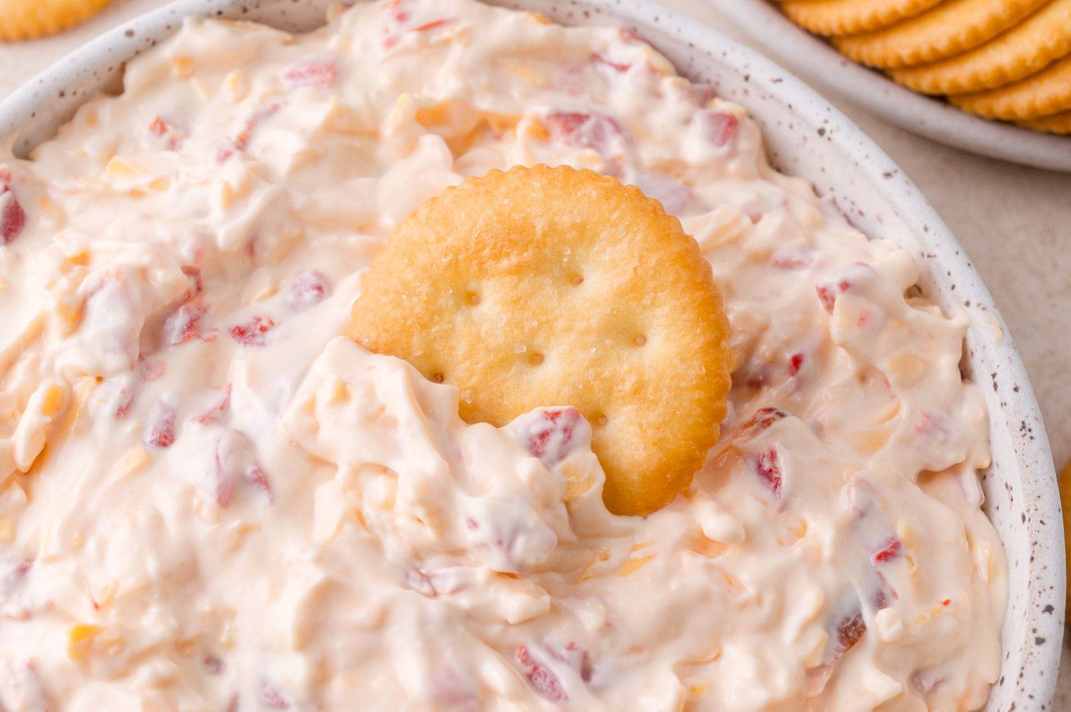 Pimento cheese with a buttery cracker dipped into it.